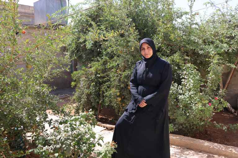 Samaher with the plants she cultivates in her small garden.