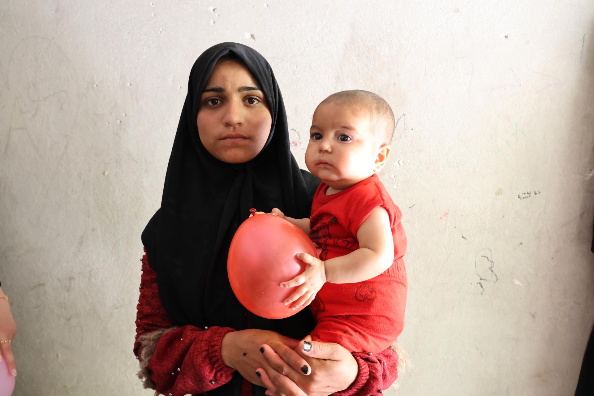 una madre siria sostiene a su bebé en brazos