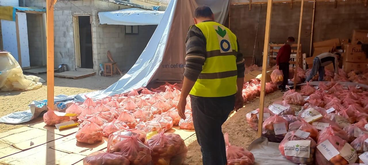 un trabajador humanitario de Acción contra el Hambre en Gaza revisa paquetes de comida para su distribución a las personas desplazadas por el conflicto