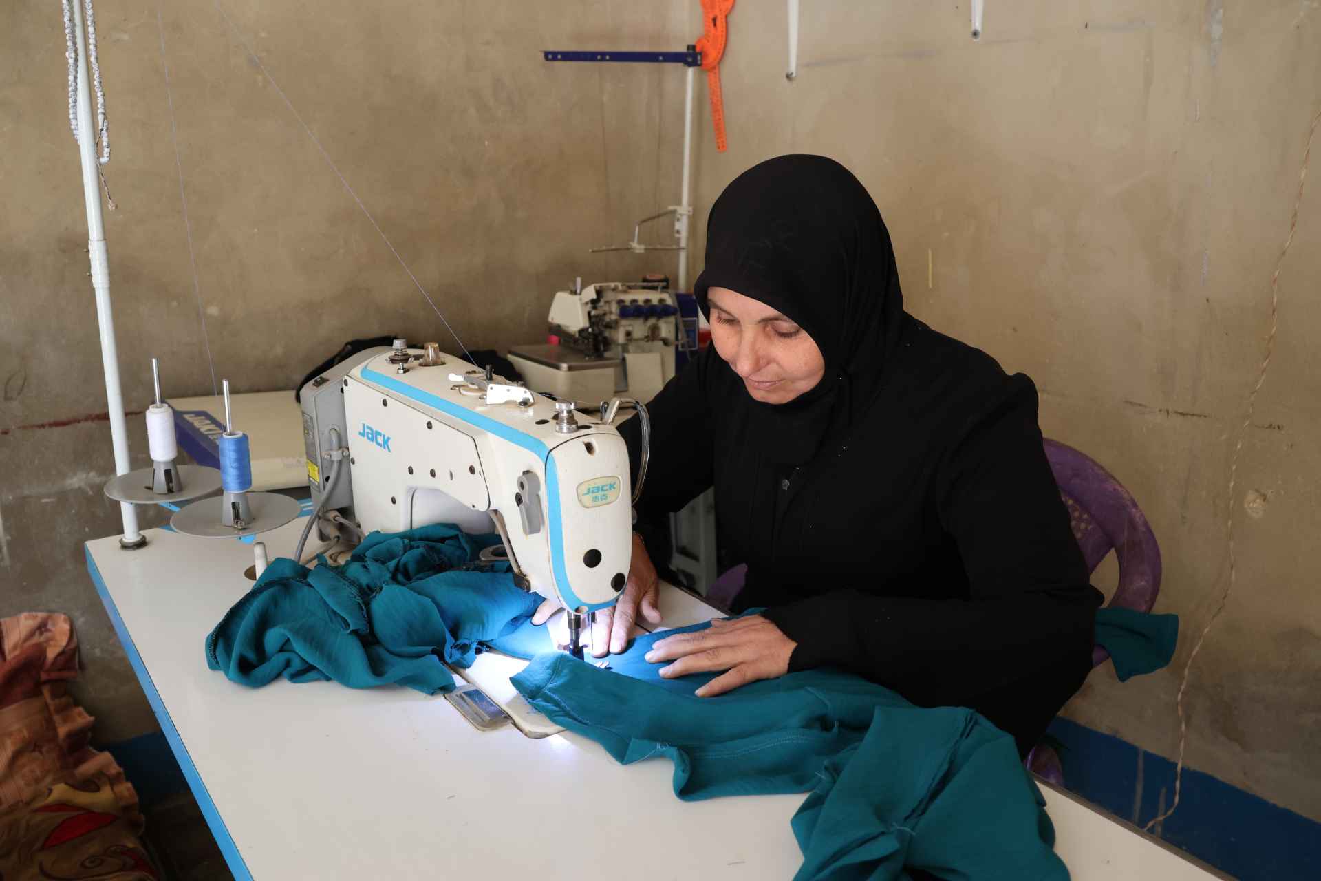 Samaher works at her sewing machine