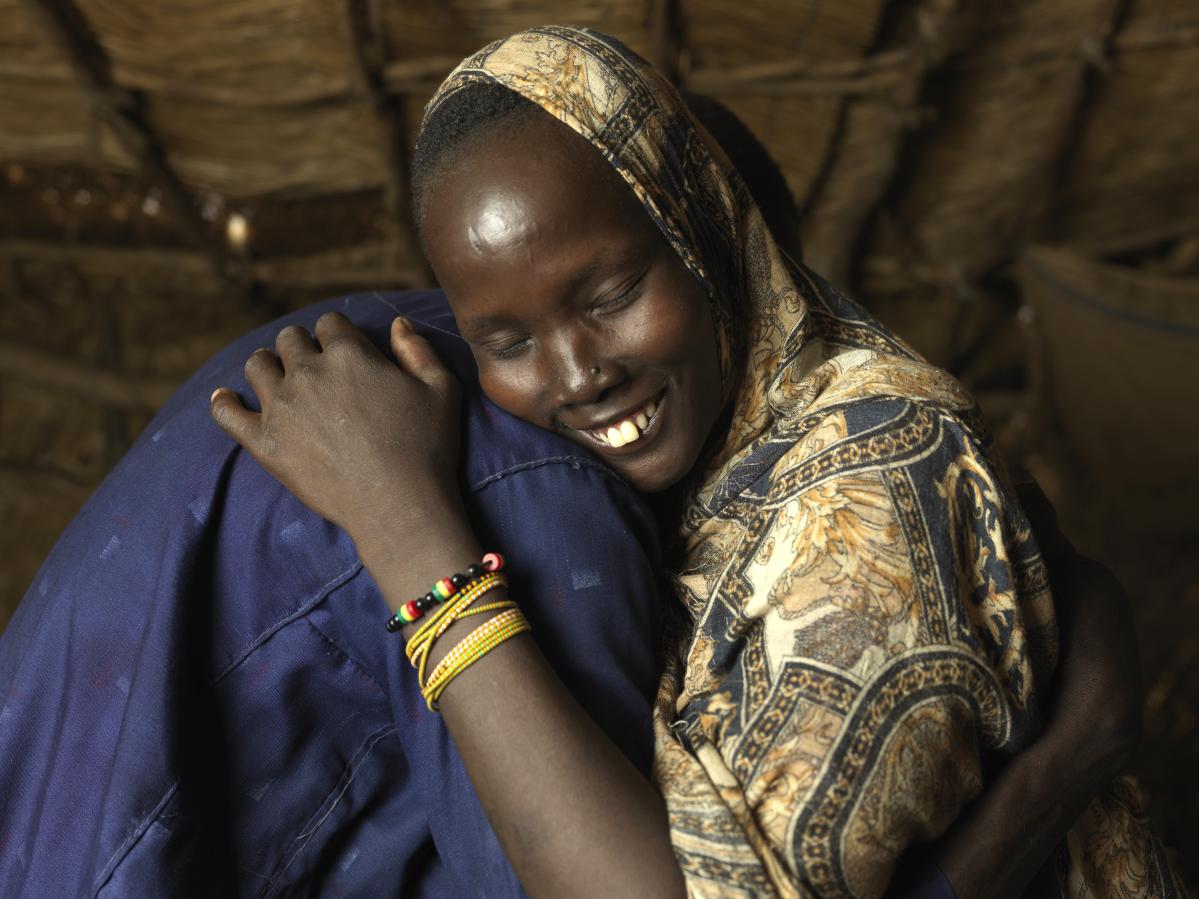 Nyibol Mathiang Deng, de 27 años, se reúne con su marido y su hija mayor tras haber estado separados durante más de un mes después de un ataque selectivo en su aldea de Sudán. © Peter Caton para Acción contra el Hambre
