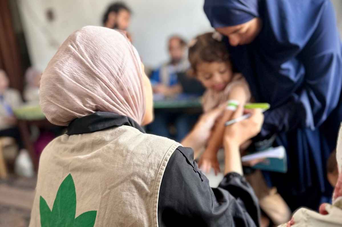 Trabajadora centro nutrición midiendo niño